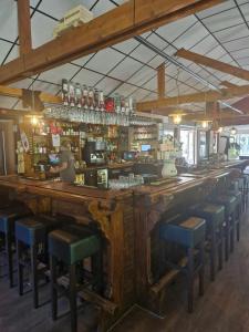 een bar met blauwe krukken in een bar met een bar bij Lege Kampeerplaats, Camping Alkenhaer in Appelscha