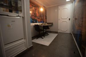 a small kitchen with a table and a refrigerator at Hotel Show Adult Only in Rio de Janeiro