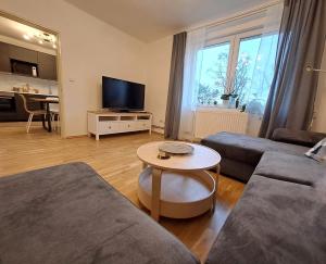 a living room with a couch and a table at Apartmánový dům se zahradou v klidné části Prahy in Prague