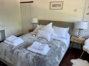 a bed with two white pillows on top of it at The Long House in Flax Bourton