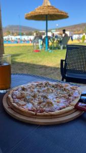 uma pizza sentada numa mesa ao lado de um copo de cerveja em Hotel MASSINE 