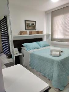 a bedroom with a large bed with blue sheets at L316 LA Apartamento aconchegante resort à beira lago in Brasilia