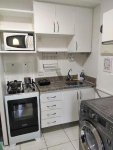a small kitchen with a stove and a microwave at L316 LA Apartamento aconchegante resort à beira lago in Brasilia