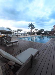 una piscina con tumbonas y una terraza de madera en L316 LA Apartamento aconchegante resort à beira lago, en Brasilia