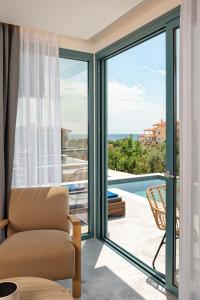ein Wohnzimmer mit einer Glasschiebetür und Poolblick in der Unterkunft Villa Gonates in Limenaria