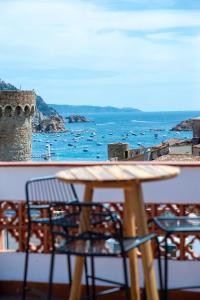 einen Tisch und Stühle auf einem Balkon mit Meerblick in der Unterkunft Hostal Boutique Es Menut in Tossa de Mar