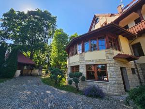 una casa grande con una entrada de piedra delante de ella en Villa Alexandra, en Polanica-Zdrój