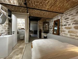 a bedroom with a bed and a stone wall at Ego HOME in Cluj-Napoca