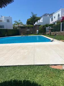 een zwembad in een tuin naast een huis bij Casa adosada Huerta del Prado in Marbella