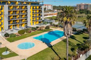 an aerial view of a hotel with a swimming pool and palm trees at Stunning Exclusive Parque Atlântico in Quarteira