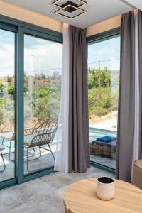 sala de estar con puertas correderas de cristal y mesa en Villa Gonates, en Limenaria