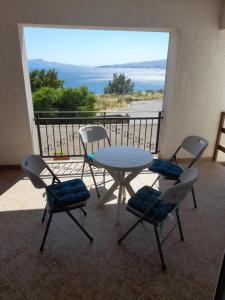 a table and chairs on a balcony with a view of the ocean at Apartments Radica in Senj