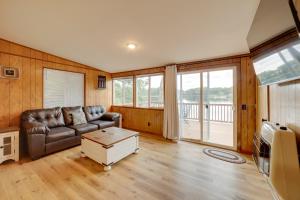 ein Wohnzimmer mit einem Ledersofa und einem Tisch in der Unterkunft Waterfront Lake Cabin Close to Boating and Fishing! in Lake