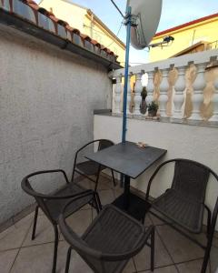 una mesa y sillas en un balcón con sombrilla en Aretha apartman i sobe en Novi Vinodolski