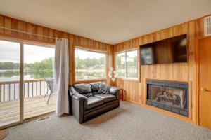 a living room with a fireplace and a tv at Lake Vacation Rental with Deck and Gas Grill! in Lake