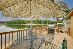 einen Tisch und Stühle auf einer Terrasse mit einem Sonnenschirm in der Unterkunft Waterfront Lake Cabin Close to Boating and Fishing! in Lake