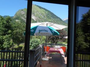 een patio met een tafel en een parasol bij appartement 8 places 9 quartier Pon in Laruns