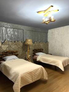 1 dormitorio con 2 camas y ventilador de techo en ARTSIV Guesthouse, en Dilijan