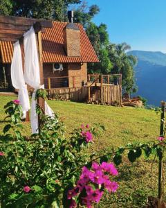 新彼得羅波利斯的住宿－Cabanas Bougainville Hospedagem sofisticada em nova Petrópolis，前面有粉红色花的房子