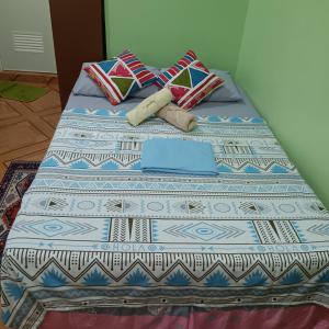 Bett mit blauer und weißer Bettwäsche und Kissen in der Unterkunft Susing Seaside Guesthouse in Moalboal