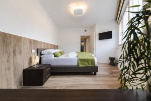 een slaapkamer met een bed met groene lakens en een tafel bij Boutique Apartments by Annalisa in Nago-Torbole