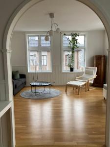 an archway in a living room with a table and a chair at Cozy and light apartment. in Bergen