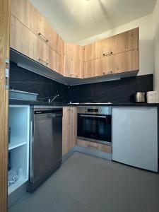una cocina con electrodomésticos de acero inoxidable y armarios de madera en apartman Marko Malinska, en Malinska