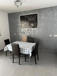 comedor con mesa, sillas y una foto en apartman Marko Malinska, en Malinska