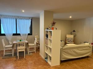 a bedroom with a bed and a table and chairs at apartamento luanco playa in Luanco