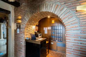 a brick hallway with a desk with a laptop on it at YIT Abentofail in Guadix