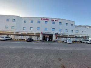 延布سي مون قمر البحر的一座白色的大建筑,汽车停在停车场