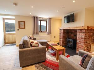 a living room with two couches and a fireplace at Llety Dewi in Oswestry