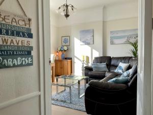 The KinBrae Apartment في توركواي: غرفة معيشة مع أريكة وطاولة زجاجية