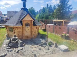 a small wooden house with a black roof at Ferienwohnung 2 am Hofladen Hellendorf in Bad Gottleuba