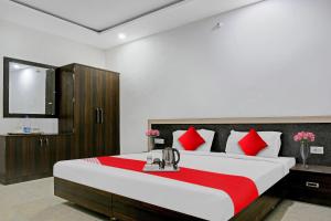 a bedroom with a large bed with red pillows at Super OYO Flagship 93079 Hotel Paradise in Varanasi