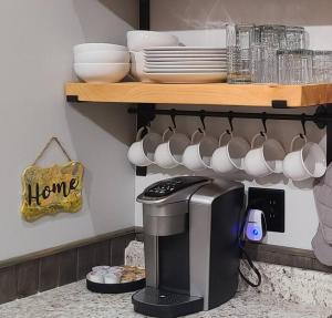a kitchen with a coffee maker and cups and a shelf at Holly Nest a Cozy Cabin Getaway near Gatlinburg in Cosby