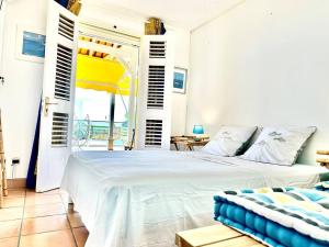 1 dormitorio con cama y vistas al océano en VILLA PASKEDRA en Case-Pilote