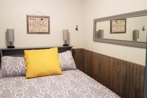 a bedroom with a yellow pillow on a bed at Holly Nest a Cozy Cabin Getaway near Gatlinburg in Cosby