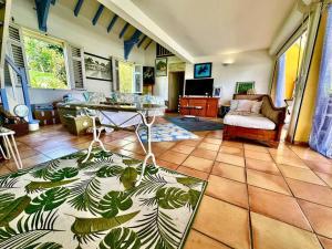 a living room with a table and a couch at VILLA PASKEDRA in Case-Pilote