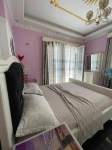 a bedroom with a white bed and a pink wall at Villa Selcotis in Golem