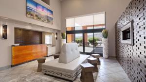 a living room with a white chair and a large window at Best Western Socorro Hotel & Suites in Socorro