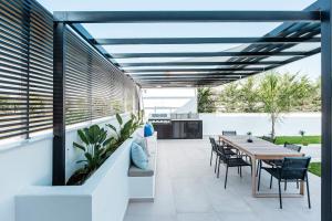 an outdoor patio with a wooden table and chairs at Sunshine Villa in Nafplio
