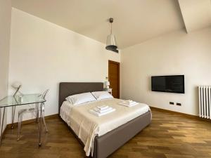 Schlafzimmer mit einem Bett, einem Schreibtisch und einem TV in der Unterkunft MiParia 154 HOME HOLIDAY in Palermo