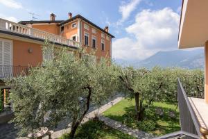 einen Blick vom Balkon eines Hauses mit Olivenbäumen in der Unterkunft Residenza di Prestigio In Riva al Lago Marone Primo Piano in Marone
