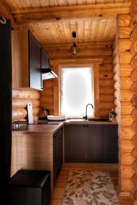 a kitchen in a log cabin with a sink and a window at Osada Lubniewice - Domki letniskowe nad samym jeziorem na wynajem 2-8osób in Lubniewice