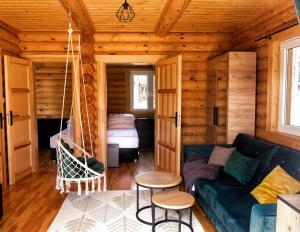ein Wohnzimmer mit einem Sofa und einem Bett in der Unterkunft Osada Lubniewice - Domki letniskowe nad samym jeziorem na wynajem 2-8osób in Lubniewice