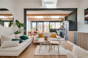 - un salon avec un canapé blanc et une table dans l'établissement Fabuleuse maison/jardin d’architecte proche Paris, à Saint-Denis