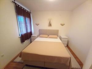 1 dormitorio con cama y ventana en Apartments Belvedere - A2, en Nečujam