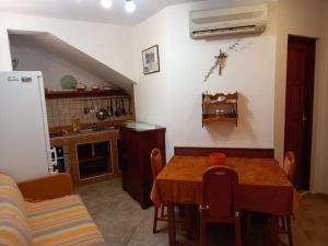 eine Küche mit Esstisch und eine Küche mit Kühlschrank in der Unterkunft Apartments Belvedere - A2 in Nečujam