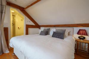 een slaapkamer met een groot wit bed met 2 kussens bij Jane Welsh Cottage in Thornhill